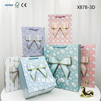 Sacs en papier carrés de marque avec poignée en ruban doré, gaufrés, pour emporter, de la marque Papier Packaging
