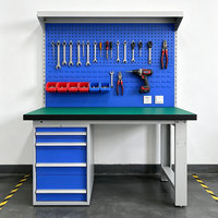 Table de travail d'atelier avec panneau perforé vertical, armoire latérale et prise de courant intégrée pour l'exploitation en usine