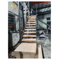 Escalier flottant moderne avec intégration murale en béton, marches en bois de frêne, éclairage LED intégré aux marches, main courante minimaliste