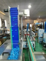 Alimentateur de capsules entièrement automatique de type élévateur et machine de capsulage rotative à quatre roues