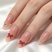 Faux ongles à presser en amande, nude transparent, avec nœud rouge 3D, ligne de perles et gemmes émeraude argentées, finition brillante, vente en gros, personnalisables, marque privée