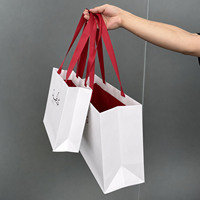 Sac de shopping en papier blanc de luxe avec logo arabe personnalisé et ruban en satin rouge pour boutique du Moyen-Orient