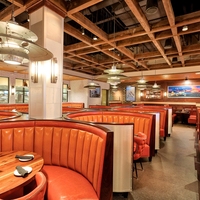 Ensemble de banquettes de restaurant sur mesure UPTOP, canapé en cuir orange, table de bar et ensemble de chaises