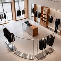 Présentoir à vêtements certifié ETL, en acier inoxydable noir, courbé, autoportant, avec table de présentation pour boutique