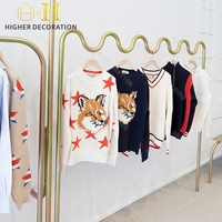 Présentoir mural rotatif pour vêtements d'enfants, mobilier de vitrine pour boutique de vêtements minimalistes à courbes ondulées