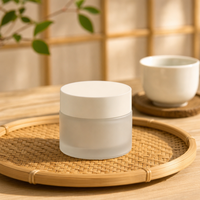 Pot de crème cosmétique minimaliste, surface givrée lisse, couvercle à vis blanc, conteneur à large ouverture
