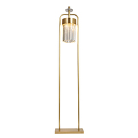 Lámpara de pie moderna con marco de latón y pantalla cilíndrica de cristal blanco, iluminación minimalista para decoración de habitaciones de hotel.