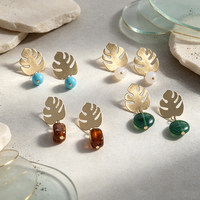 Boucles d'oreilles créoles motif feuille tropicale, en laiton artisanal, design ajouré, avec feuilles de bambou évoquant une coquille de tortue et pierres turquoise. Oreille