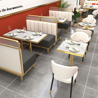 Banquette de restaurant avec cadre doré, cloison de séparation en verre intégrée, sièges modernes en cuir blanc, idéale pour centre commercial et hôtel