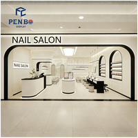 Aménagement moderne de salon de manucure et mobilier sur mesure : tables de manucure, comptoir de réception et vitrines pour vernis à ongles