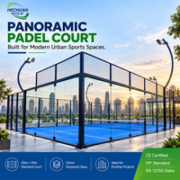 Terrain de padel panoramique Hechuan Clear Sightline en acier noir avec 18 panneaux en verre trempé et gazon artificiel bleu pour clubs urbains