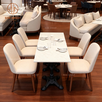 Ensemble de mobilier de restaurant, café et hôtel : canapé, table et chaises en velours blanc, avec banquette minimaliste carrée en pierre.