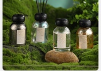 Bouteille de diffuseur d'arôme en verre coloré rond de 110ml en gros avec des bâtons de fibre noire parfum de maison pour diffuseur de roseau caractéristique fraîche