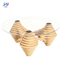 Table basse moderne et écologique au design unique avec plateau en verre transparent et pieds en bois empilés artistiquement pour salon, espace de réception à domicile