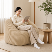Neu eingetroffener Akzentstuhl: Luxuriöses, beige, abgerundetes Sofa mit breiter Sitzfläche in Kompressionsverpackung für moderne Wohnzimmer