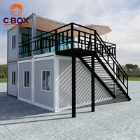 Maison conteneur préfabriquée Cbox à deux étages avec mur-rideau en verre, escalier extérieur en acier et terrasse sur le toit