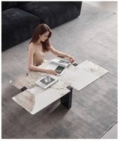 Un salon moderne italien de luxe léger et minimaliste avec une table basse en acier inoxydable de forme irrégulière