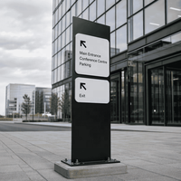 Panneau de signalisation directionnel noir monolithique avec flèches blanches pour la signalisation des campus d'entreprise