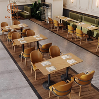 Ensemble de meubles modernes pour café, restaurant, salon de thé : canapés incurvés verts, tables rondes en bois et chaises oranges