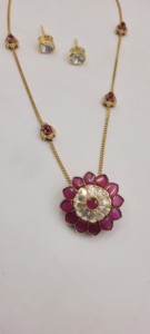Ensemble de pendentifs fleuris plaqués or rubis, comprenant un pendentif floral central avec des pierres rouges et des accents blancs, et une chaîne délicate. - Product Image 4