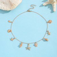 Collier chaîne en or avec 9 breloques marines : étoile de mer, tortue, dollar de sable, conque – Bijoux de plage pour femme