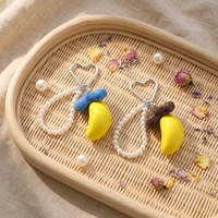 Vente en gros : Breloque de sac banane Kawaii tendance, porte-clés avec nœud et chaîne de perles et fermoir cœur, cadeau adorable pour filles