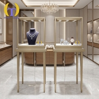 Vitrine de luxe en verre en forme de dôme avec éclairage LED et base métallique pour présentation de bijoux haut de gamme en boutique ou en showroom