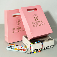 OEM/ODM personnalisé de luxe Shopping estampage à chaud or sac en papier vente en gros vêtements bijoux sacs en papier avec poignée découpée