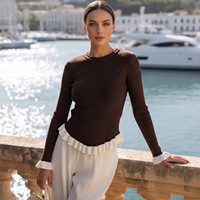 Élégant pull tricoté patchwork noir et blanc pour femme, col rond, manches longues, poignets à volants blancs, bas plissé, coupe ajustée
