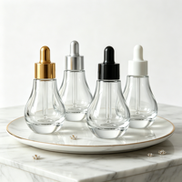 Flacon compte-gouttes en verre transparent rond créatif de 30 ml avec étiquettes personnalisées OEM/ODM pour le stockage d'huiles essentielles, de parfums et d'essences