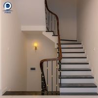 Escalier en L vintage personnalisé Prima en pierre noire avec main courante en bois foncé et balustres en fer ornés de laiton pour manoir classique