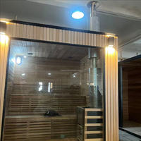 Sauna extérieur moderne en bois massif avec douche intégrée et poêle à bois