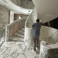Escalier en spirale mural monolithique incurvé de style loft moderne avec marches en marbre Calacatta Viola pour maison