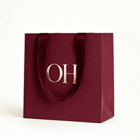 Sac shopping en papier bordeaux premium avec logo estampé à chaud et poignée en ruban, personnalisé pour l'emballage cadeau de marques de luxe