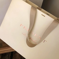 Sac en papier personnalisé pour marque de vêtements, sac en papier cartonné blanc 250g, logo imprimé or rose, design avec ruban suspendu