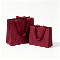 Sac en papier de luxe bordeaux à motif gaufré avec poignée en ruban gros-grain et nœud décoratif pour boutique de vêtements