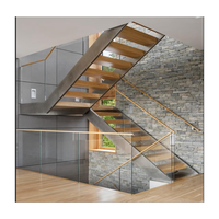 Escalier sur mesure à double poutre, structure en acier en U, marches en hêtre massif, panneaux en verre, finition blanche thermolaquée