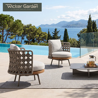 Fauteuil de salon sculptural tressé avec dossier en corde croisée, base de siège ronde et coussins pour projets de villas de luxe et terrasses - Vente en gros