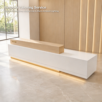 Comptoir de réception simple en bois blanc avec bande LED, personnalisable avec la marque, pour hall d'hôtel ou réception.