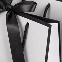 Sac de luxe personnalisé en papier blanc avec bordure noire, poignée en corde, ruban et nœud, sac cadeau à poignée torsadée, sac boutique à soufflets