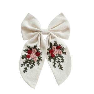 Fabricant de pinces à cheveux en tissu texturé blanc crème faites à la main, avec nœuds floraux brodés et délicats rubans brodés - Product Image 1