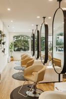 Miroir de salon ovale pleine longueur avec cadre doré, argenté et noir, et bande de connexion au pilier du plafond