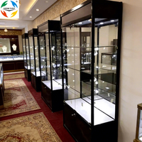 Vitrine de présentation moderne de luxe sur mesure avec mur en verre trempé, éclairage LED, cadre en aluminium, construction robuste pour usage commercial