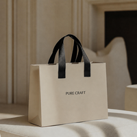 Sacs cadeaux en papier noir de luxe personnalisés avec impression florale et poignées en corde pour l'emballage de bouteilles