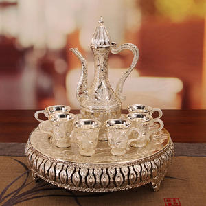Service à thé en métal finition argentée ornée avec carafe gravée, six tasses décoratives et plateau de service rond embossé pour un cadeau de luxe - Product Image 1