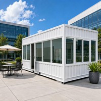 Maison préfabriquée à ossature en acier blanc avec panneaux muraux entièrement vitrés et porte à charnières, prête à l'emploi pour usine, entrepôt ou livraison rapide.