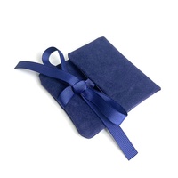 Pochette à bijoux de luxe en daim bleu foncé avec logo gaufré, doublure en satin et nœud en ruban