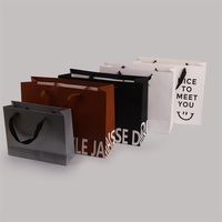 Sacs en papier kraft de luxe avec poignée en ruban Emballage de luxe imprimé personnalisé pour vêtements Cadeaux au détail bon marché du fournisseur