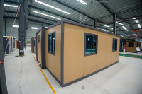 Conteneur modulaire extensible de 20 pieds avec structure grise et finition bois clair, moderne, étanche et résistant au vent, pour maison d'hôtes de jardin ou chantier