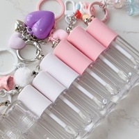 Tube à gloss transparent vide avec un grand pinceau et une chaîne d'accessoires en forme de cœur, contenant à gloss